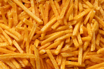 Fried chips sticks texture background, finger potato ketchup flavored chips pattern, shoestring fries