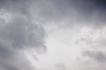 A dramatic and moody sky filled with thick, dark grey storm clouds creating a textured background