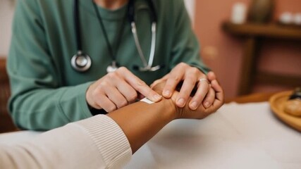Nurse applies adhesive bandage to patient wrist in clinic. - Powered by Adobe