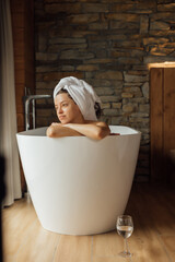 Woman relaxing in a modern bathtub in a peaceful setting