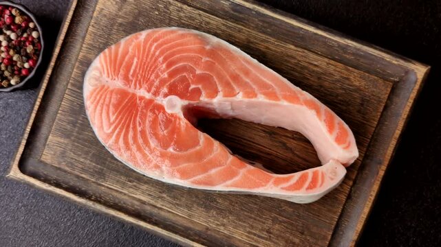 Fish, raw salmon steak, fresh seafood for grilling with salt, spices, and herbs. Raw salmon steak as a food background for your design.
