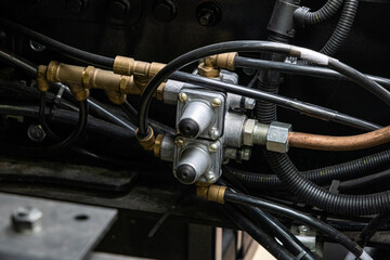 Obraz premium Brake system, semi-trailer brake lines, ABS system. Semi-trailer, truck spare parts. Tubes, various fasteners, and auto electronics. View on truck chassis frame equipment. Truck back parts details