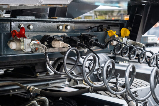 Pneumatic pumping hoses and connections of the body with the trailer to the truck. Closeup of pneumatic hoses for supplying compressed air to the truck. Semi-trailer, Truck MOT maintenance repair.