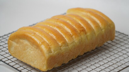 Freshly cooked golden brown comb bread is served on a cooling rack placed in a white place (isolated white).