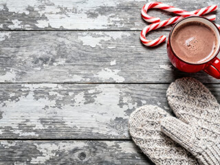 Cozy Winter Scene with Hot Chocolate Candy Canes and Mittens on Rustic Wood