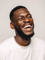 Obraz premium handsome unshaven young darkskinned male laughing out loud at funny meme he found on internet smiling broadly showing his white straight teeth positive human facial expressions and emotions no logos 