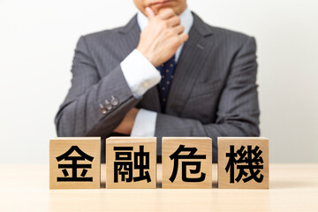 「金融危機」と書かれたブロックとビジネスマン