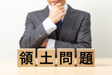 「領土問題」と書かれたブロックとビジネスマン