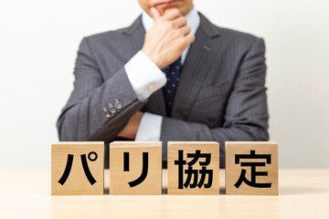 Obraz premium 「パリ協定」と書かれたブロックとビジネスマン
