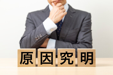 「原因究明」と書かれたブロックとビジネスマン