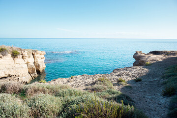 Rugged coastline with turquoise sea and sparse vegetation
