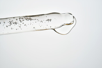 Cosmetic pipette dispensing serum with bubbles and liquid drop