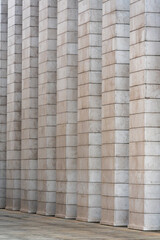 Close-up of repeating stone columns on modern building facade, architectural pattern background