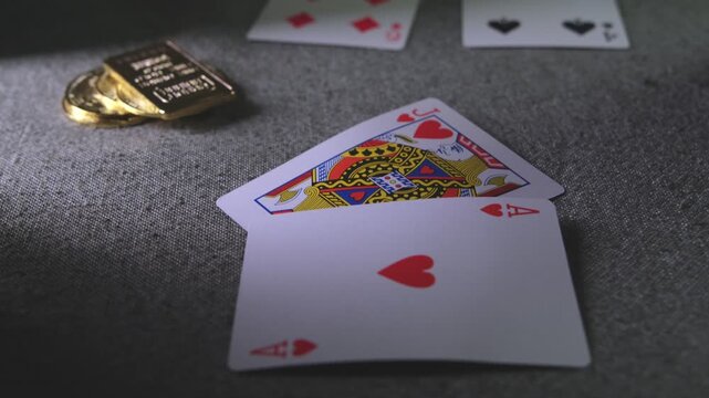 Croupier's hand dealing a winning blackjack hand next to a bet made with cryptocurrency coins