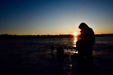 Ice fishing at sunset. 