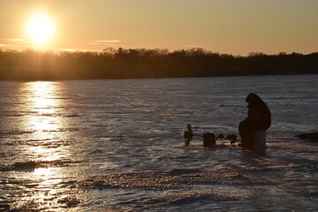 Ice fishing at sunset. 