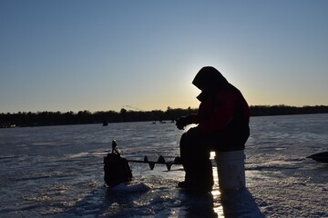 Ice fishing at sunset. 