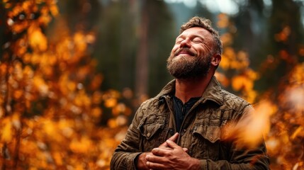 Fototapeta premium A smiling man stands amidst beautiful autumn foliage, absorbing nature's serene ambiance, radiating contentment, peace, and gratitude in a picturesque setting.