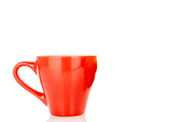 One red ceramic cup isolated on white background, close-up.