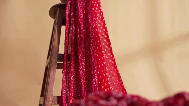 Tracking shot of red Indian saree draped on a stool captured in detailed 4K footage showcasing elegant textile movement flow