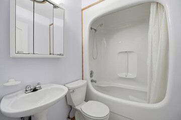 Bathroom with a white toilet, sink, and shower