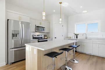 Kitchen with a white island and black stools