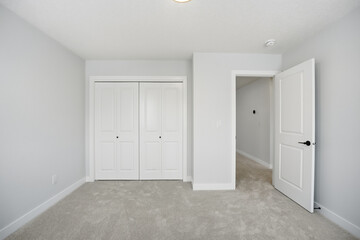 White bedroom with a white door and white closet