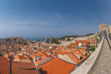 Dubrovnik, Croatia, old town panorama from the height of medieval fortress walls, with rooftops and Fort Lovrijenac in  background.