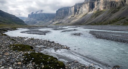 A braided river flows through a vast glacial valley surrounded by towering rocky mountains