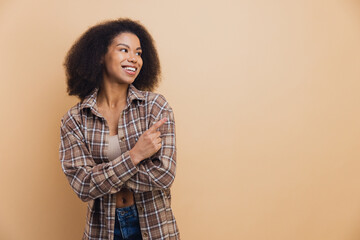 Happy African American woman pointing at copy space