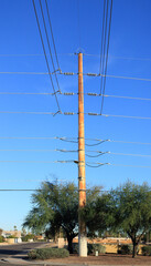 Obraz premium Tall metal electric utility pole interconnecting wires going in various directions set against a clear cloudless blue winter sky in Phoenix, Arizona