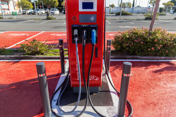 Modern electric vehicle charging station in an urban parking area, highlighting clean energy, sustainable transport, green technology, and eco friendly mobility.