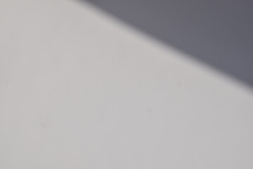 Fundo branco com sombra cinza no canto superior da imagem em formato triangular