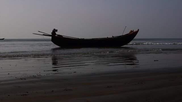 Fisherman boat parked and tossed around by sea wave, fishing boat on the sea wave beach with blue sky in India.