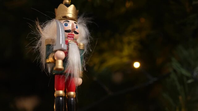 A nutcracker soldier ornament with a Christmas tree visible in the background, symbolising holiday tradition and festive Christmas spirit. 4 k video