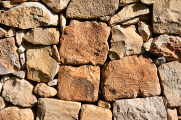 Stacked ochre-colored rough rocks, usable as background, near the coastal village of Marsaxlokk Marsaxlokk, Malta, 6 DEC 2025.