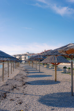 Parasols, shaders on a pebble beach on island of Vir, Croatia. Famous tourist destination.