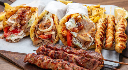 Gyro sliced meat pita bread wraps, pork souvlaki skewers, traditional street food, closeup
