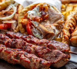 Gyro sliced meat pita bread wraps, pork souvlaki skewers, traditional street food, closeup