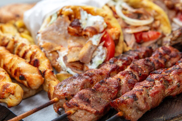 Gyro sliced meat pita bread wraps, meat souvlaki skewers, traditional street food, closeup