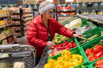 Elderly Woman Choosing Fresh Zucchini in Supermarket Produce Section – Healthy Eating and Independent Senior Shopping. healthy eating habits, conscious food choices, active senior lifestyle, independe