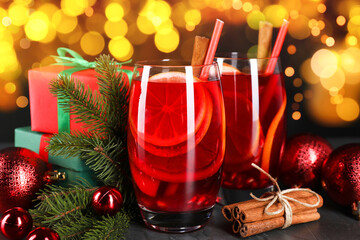 Sangria drink for Christmas. Tasty beverage in glasses and decor on table against bokeh lights