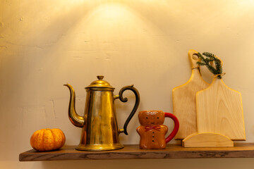 Vintage kitchen decor with gingerbread mug, pumpkin, and wooden cutting boards
