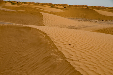 detalhe de dunas de areia fina e coloridas no deserto do saara, tun&iacute;sia.