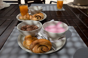 Pormenor do pequeno-almo&ccedil;o numa mesa de madeira ao ar livre.