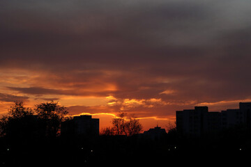 Cloudy orange sky at sunset over city buildings in Bucharest