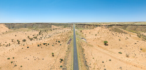 This high-quality drone photograph presents a sweeping aerial round flight over the dramatic landscapes of Namibia, offering a breathtaking bird’s-eye view of one of the world’s oldest deserts. The ca