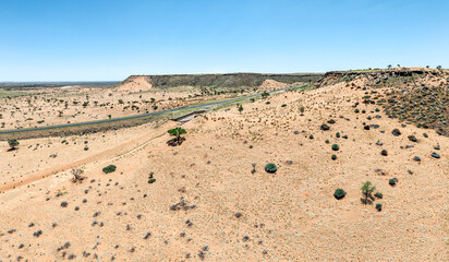 This high-quality drone photograph presents a sweeping aerial round flight over the dramatic landscapes of Namibia, offering a breathtaking bird’s-eye view of one of the world’s oldest deserts. The ca