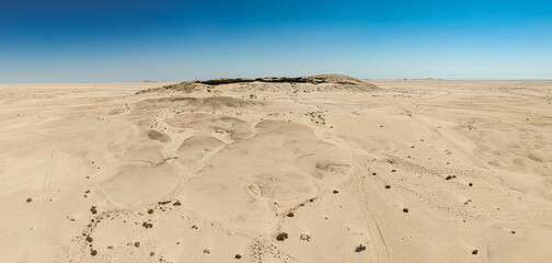 This high-quality drone photograph presents a sweeping aerial round flight over the dramatic landscapes of Namibia, offering a breathtaking bird’s-eye view of one of the world’s oldest deserts. The ca