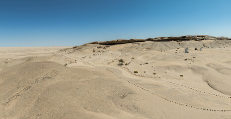 This high-quality drone photograph presents a sweeping aerial round flight over the dramatic landscapes of Namibia, offering a breathtaking bird’s-eye view of one of the world’s oldest deserts. The ca